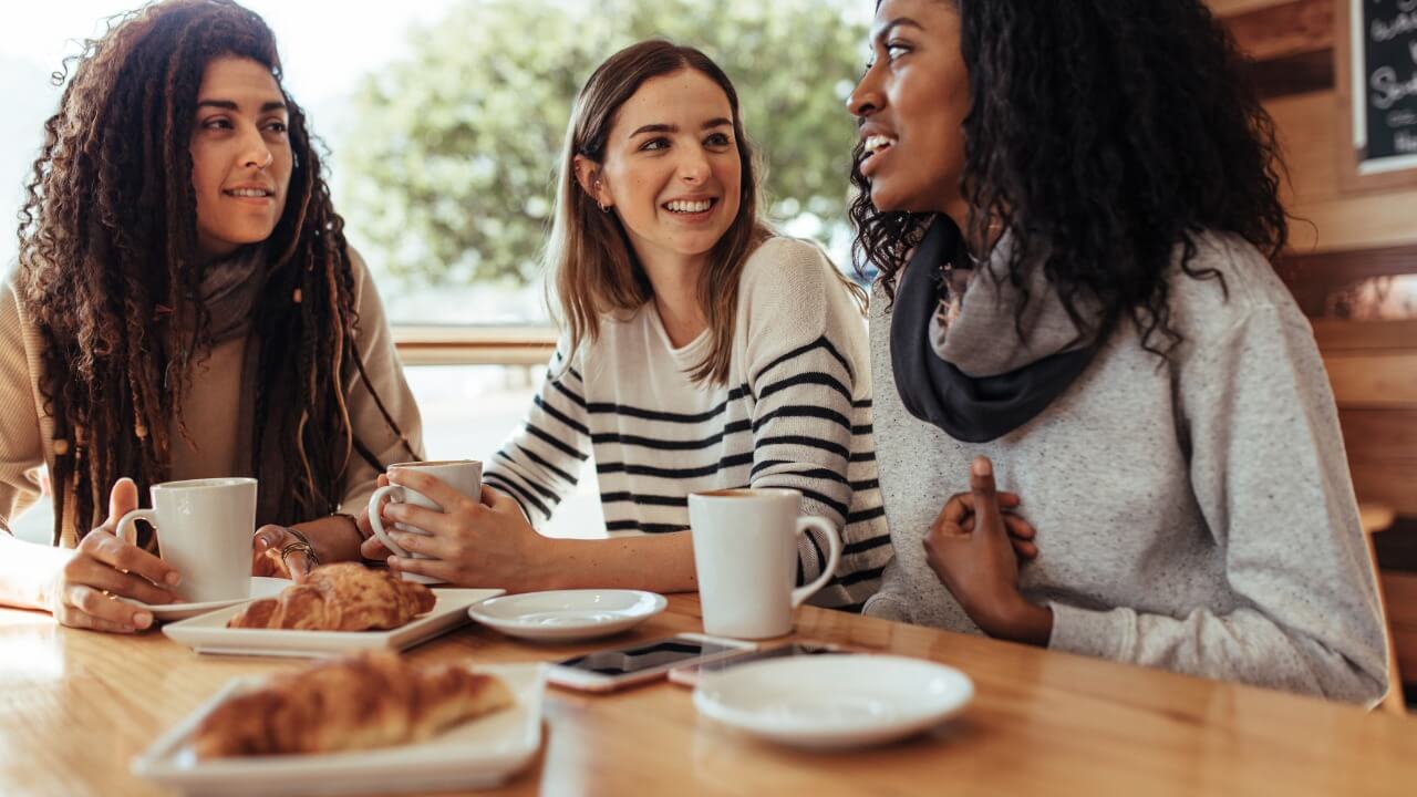 Three students enjoying breakfast at a cafe.
