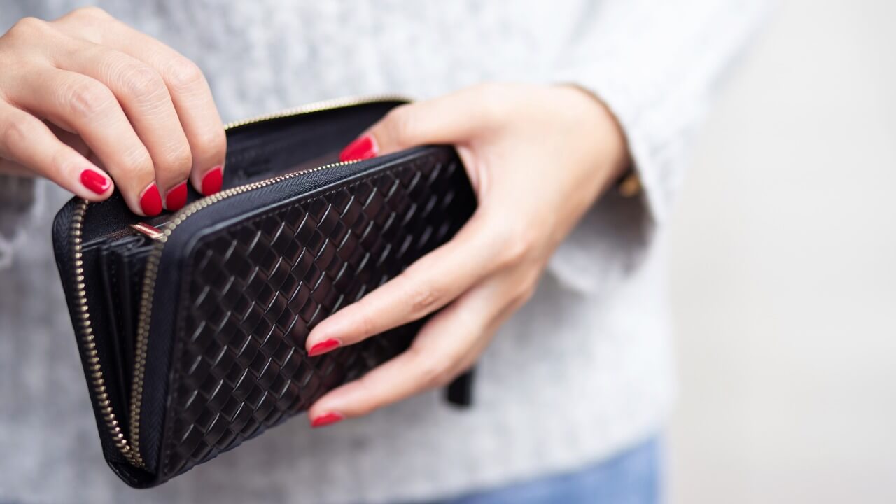 A woman opening a wallet.